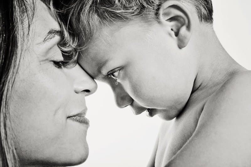 A mother and young child touching foreheads in a black-and-white portrait at Daysee photo studio