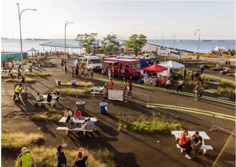 Food trucks and picnic tables at Ferry Plaza Park on the Brooklyn Army Terminal waterfront in Sunset Park