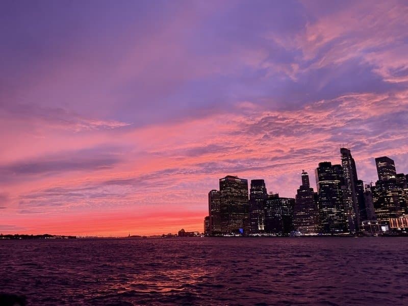 Pink and purple sunset over the Lower Manhattan skyline seen from the Brooklyn waterfront