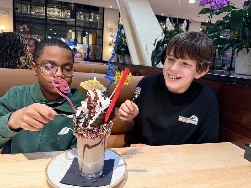 Two kids sharing an oversized decorated milkshake at Carnegie Diner & Cafe in Downtown Brooklyn